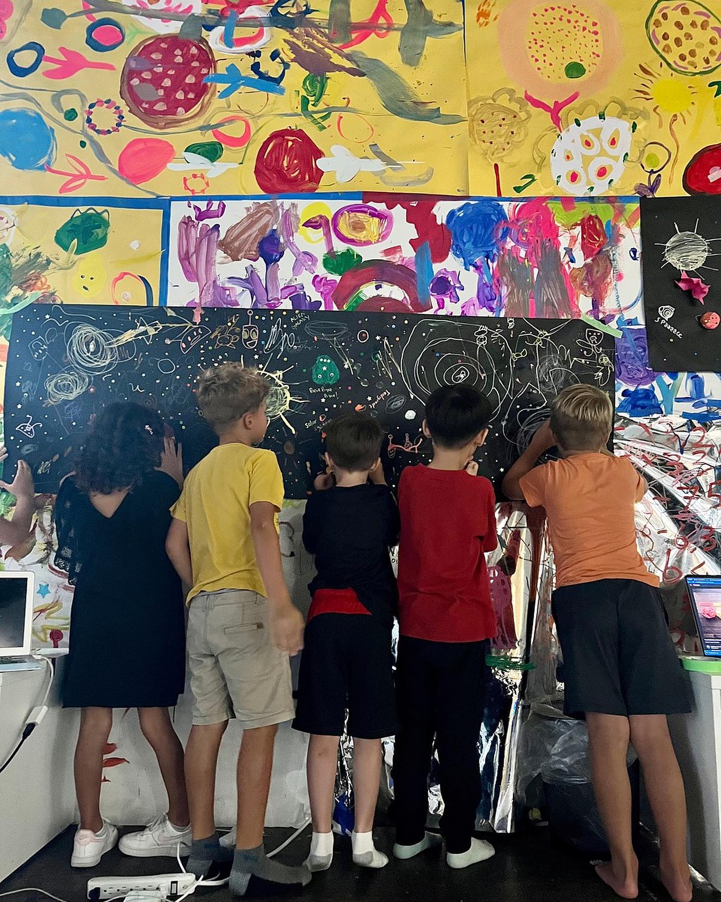 Kids painting on a mural of space