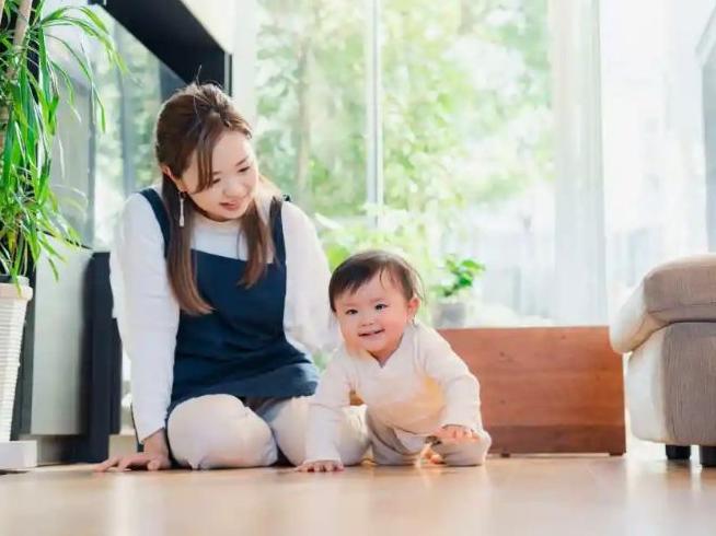 teen girl babysitting with a crawling infant